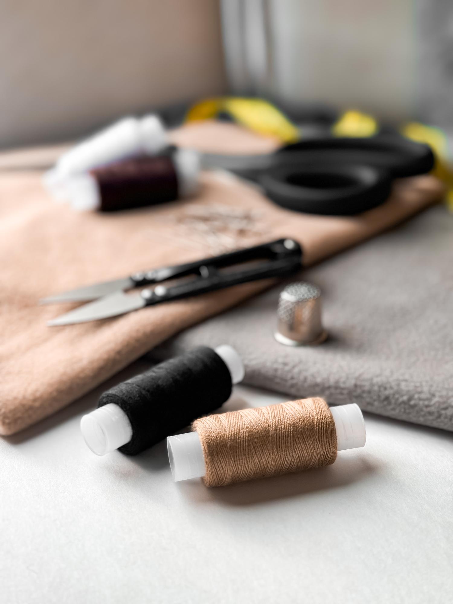 zbliżenie igły i nici na lnianej tkaninie